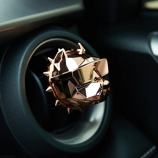 Rose Gold bulldog car vent diffuser installed in black dashboard vent.