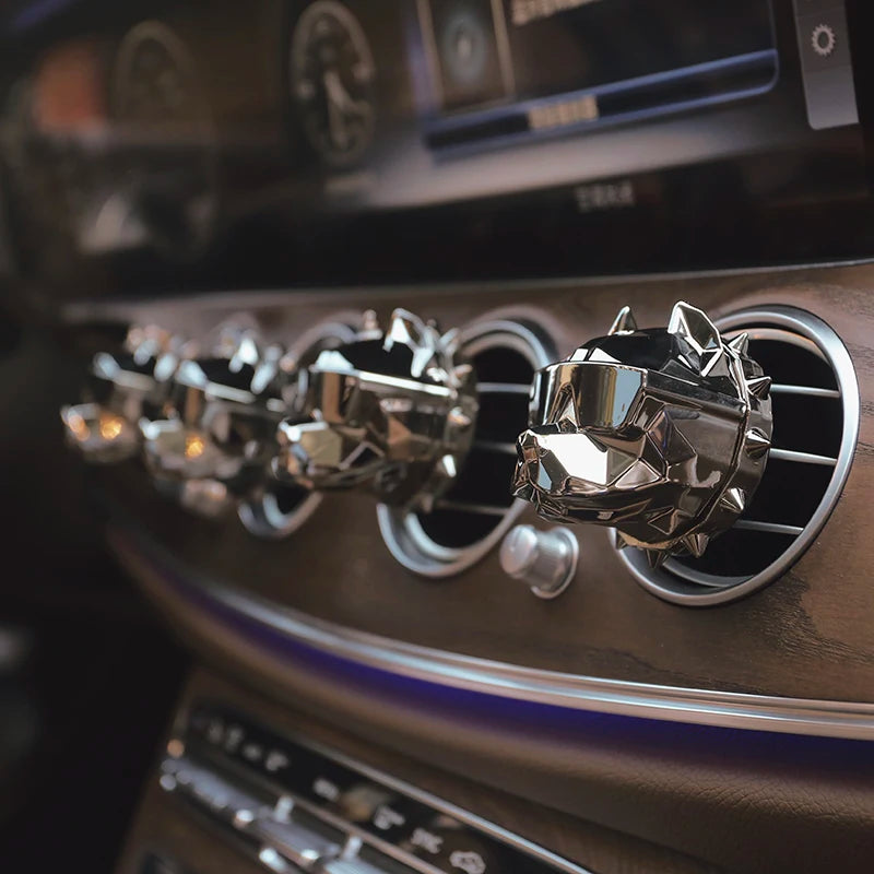 Row of metallic bulldog car vent diffusers clipped to dashboard air vents.