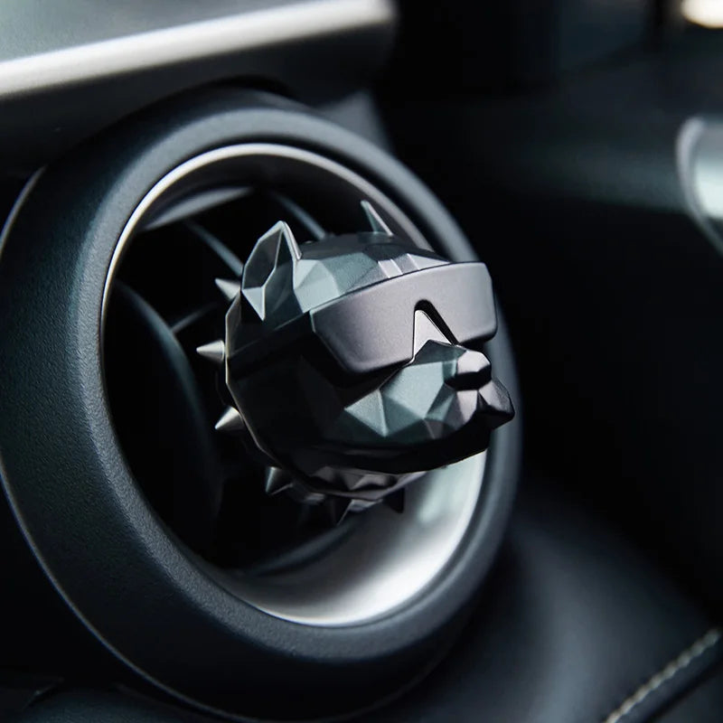White bulldog car vent diffuser clipped into black dashboard vent.
