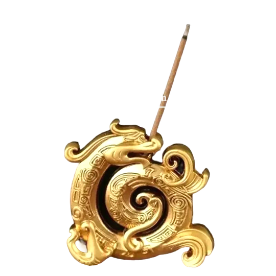 Golden dragon incense holder with spiral design, incense stick placed upright, compact decorative burner.