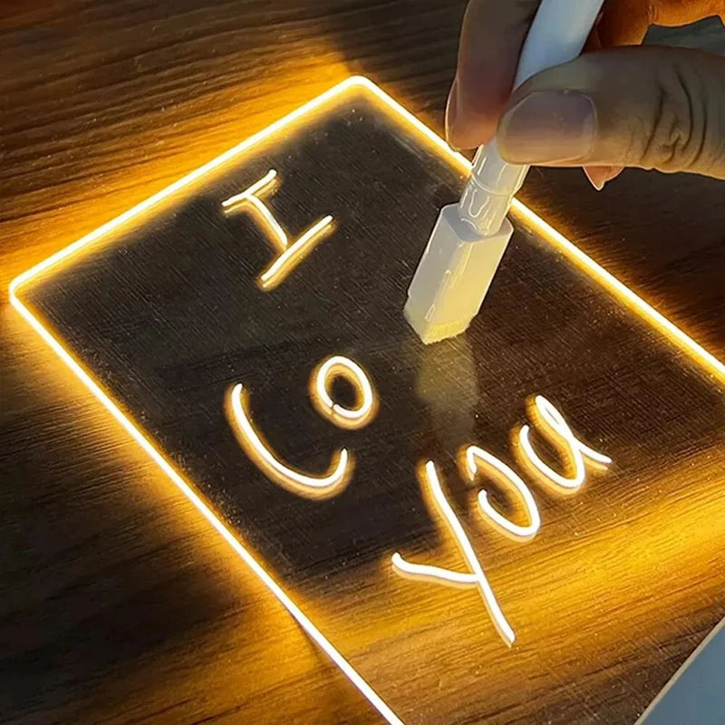 Close-up of acrylic LED message board showing handwritten note under warm glow.