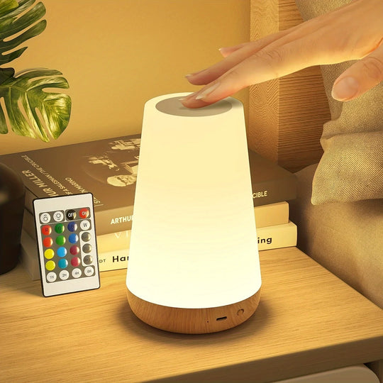 Touch-activated RGB night light on wooden nightstand with remote control.