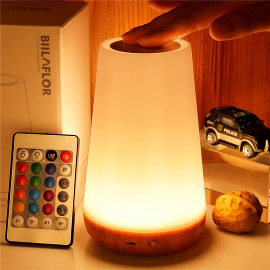 Warm yellow night light setting on wooden table with books and decor.