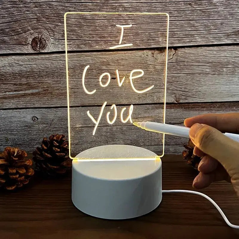 Hand writing ‘I love you’ on glowing acrylic LED message board lamp with USB base.