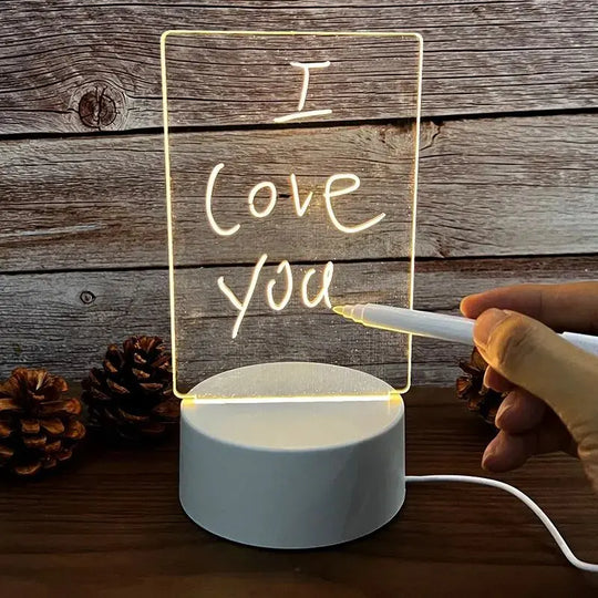 Hand writing ‘I love you’ on glowing acrylic LED message board lamp with USB base.
